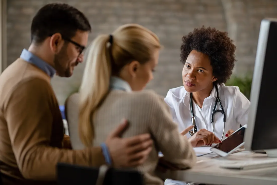 Doctor reviewing records during a medication-safety conversation.