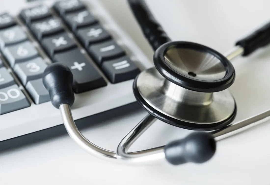 Calculator and medical paperwork used for cash-pay medication cost research.