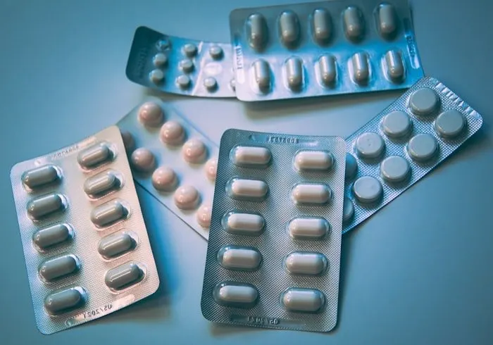 Blister packs of tablets on a blue surface.